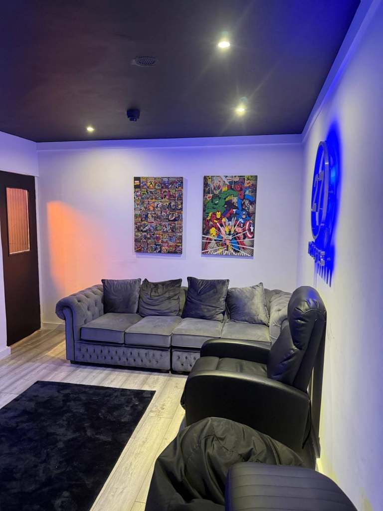 Studio 7 lounge area with a corner sofa, artwork and blue neon signage